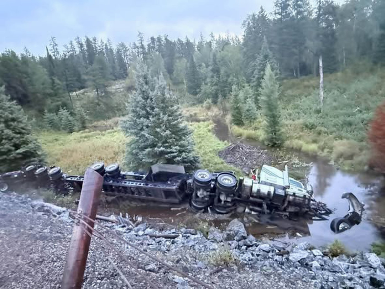 Transport truck recovered from creek after 60-foot plunge